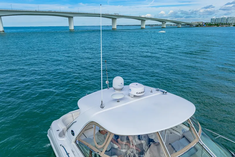 Slide: The Image of 2002 Sea Ray 460 Sundancer yacht cruising under a bridge on a sunny day. - 33