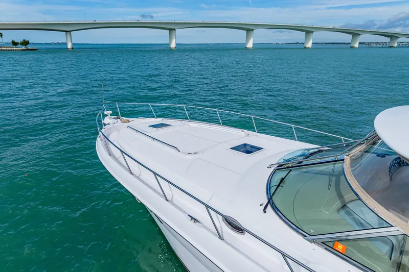 Slide: The Image of 2002 Sea Ray 460 Sundancer yacht cruising under a bridge on a sunny day. - 4