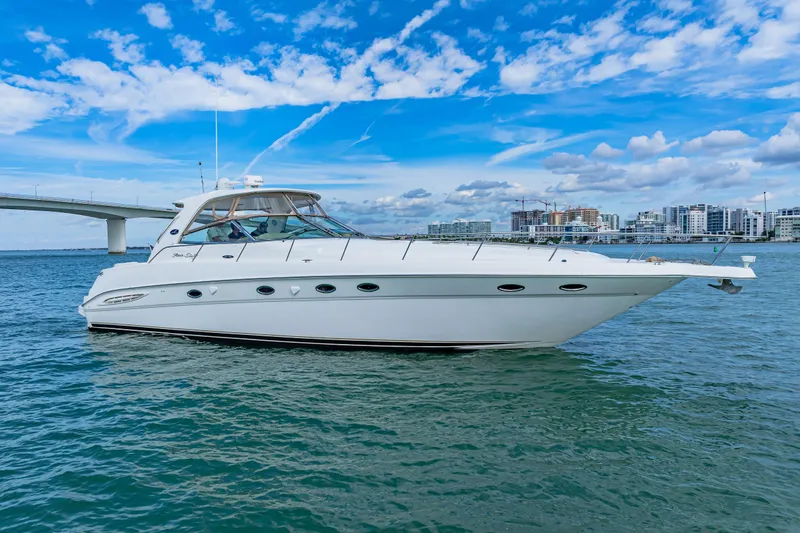 Slide: The Image of 2002 Sea Ray 460 Sundancer yacht on calm water with cityscape background. - 41