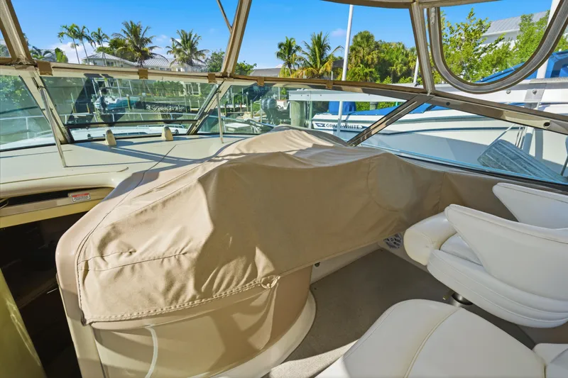 Slide: The Image of 2002 Sea Ray 460 Sundancer cockpit with covered controls and white seating. - 46