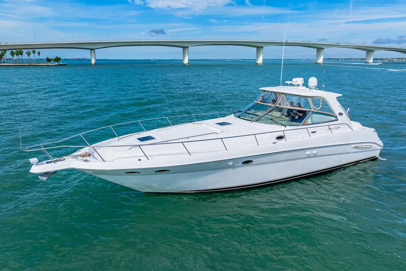 Slide: The Image of 2002 Sea Ray 460 Sundancer yacht cruising on blue waters near a bridge. - 2
