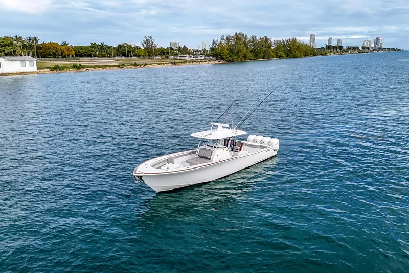 Slide: The Image of 2022 Valhalla Boatworks V-41 cruising on a calm waterway with cityscape backdrop. - 2
