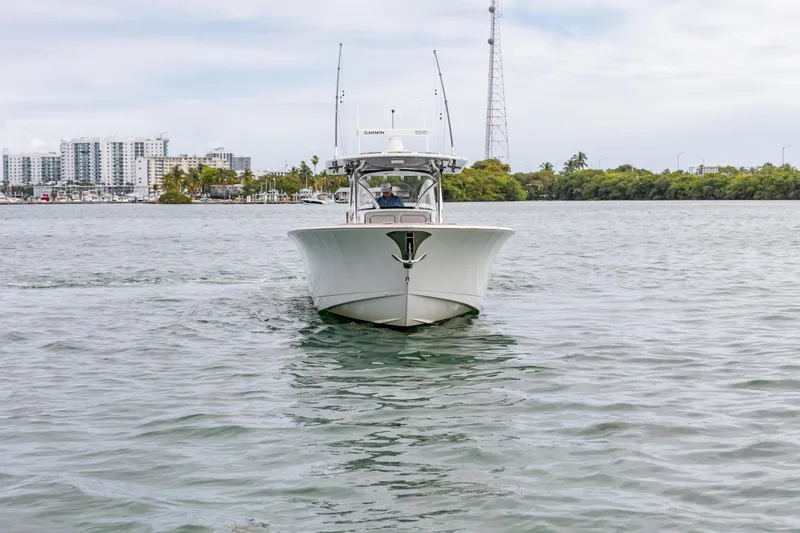 Slide: The Image of 2022 Valhalla Boatworks V-41 cruising in a harbor with industrial backdrop. - 5