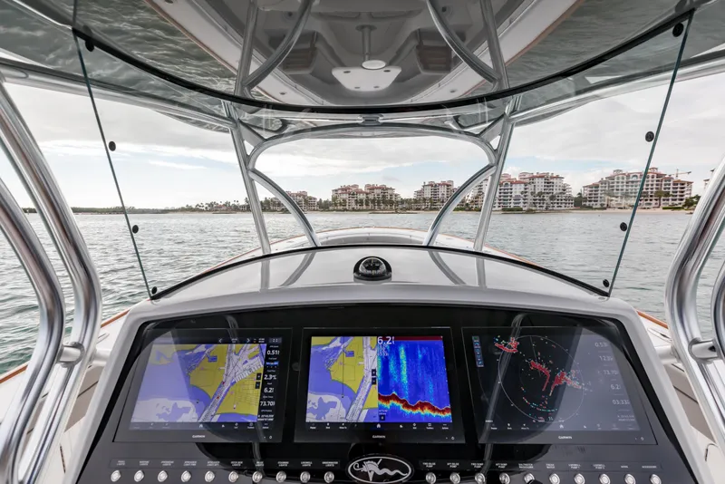 Slide: The Image of 2022 Valhalla Boatworks V-41 helm with advanced navigation displays, overlooking coastal buildings. - 8