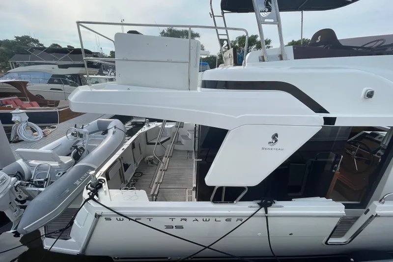 Slide: The Image of 2018 Beneteau Swift Trawler 35 docked, featuring sleek design and spacious deck area. - 12