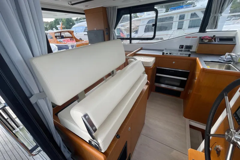 Slide: The Image of Interior of 2018 Beneteau Swift Trawler 35, featuring helm, seating, and kitchen area. - 20