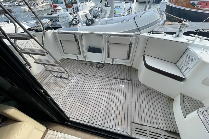 Slide: The Image of 2018 Beneteau Swift Trawler 35 cockpit with teak flooring and docked inflatable boat. - 35