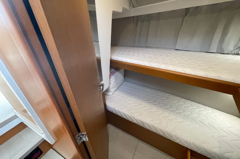 Slide: The Image of Bunk beds in 2018 Beneteau Swift Trawler 35 cabin, featuring wooden finishes. - 54