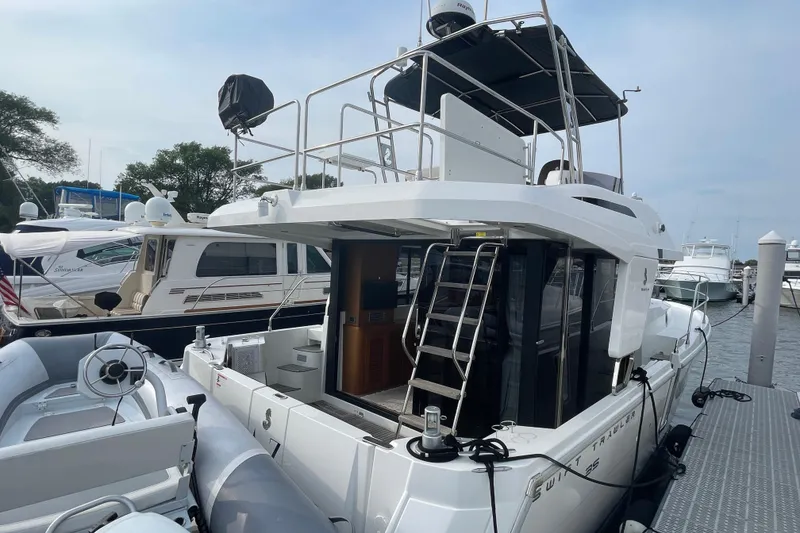 Slide: The Image of 2018 Beneteau Swift Trawler 35 docked, featuring upper deck and inflatable boat. - 7