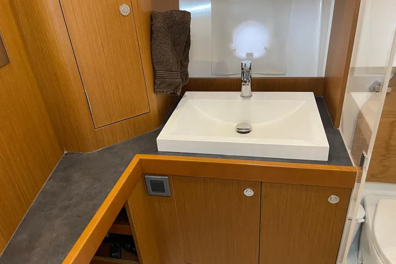 Slide: The Image of Bathroom sink area in 2018 Beneteau Swift Trawler 35, featuring modern design and wood accents. - 70