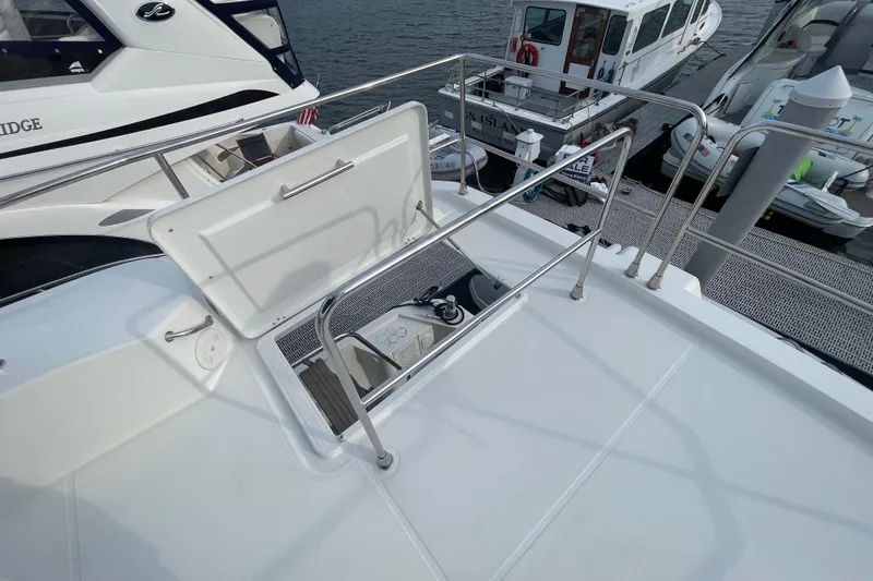 Slide: The Image of 2018 Beneteau Swift Trawler 35 deck with open hatch, docked near other boats. - 75