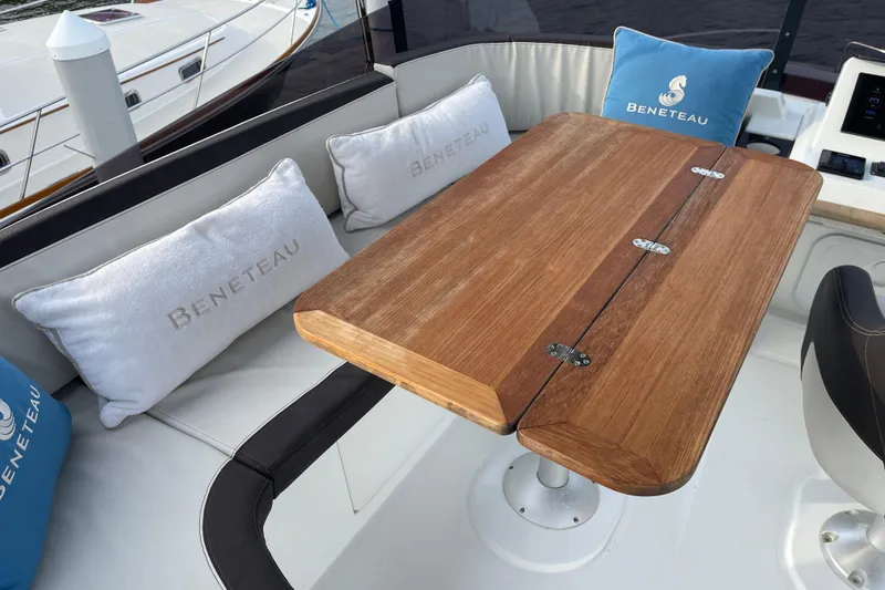 Slide: The Image of 2018 Beneteau Swift Trawler 35 interior with wooden table and branded cushions. - 82