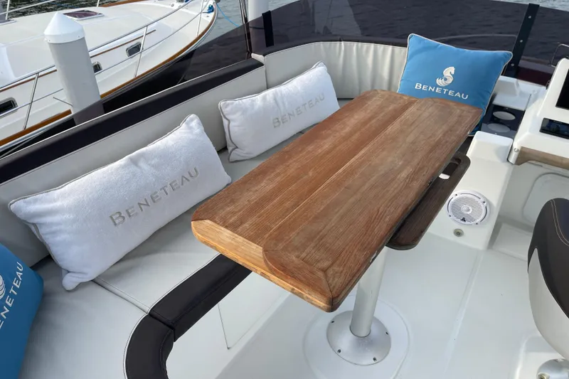 Slide: The Image of Cozy seating area on 2018 Beneteau Swift Trawler 35 with wooden table and branded cushions. - 83