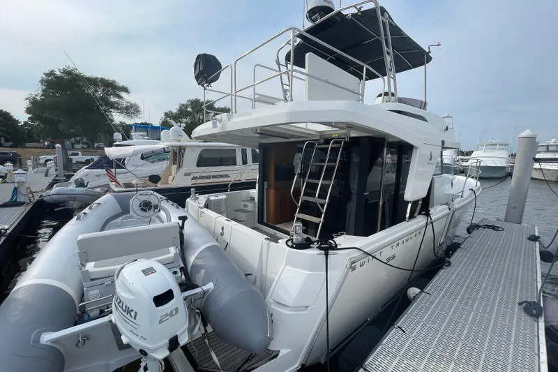 Slide: The Image of 2018 Beneteau Swift Trawler 35 docked with inflatable boat and Suzuki motor. - 9
