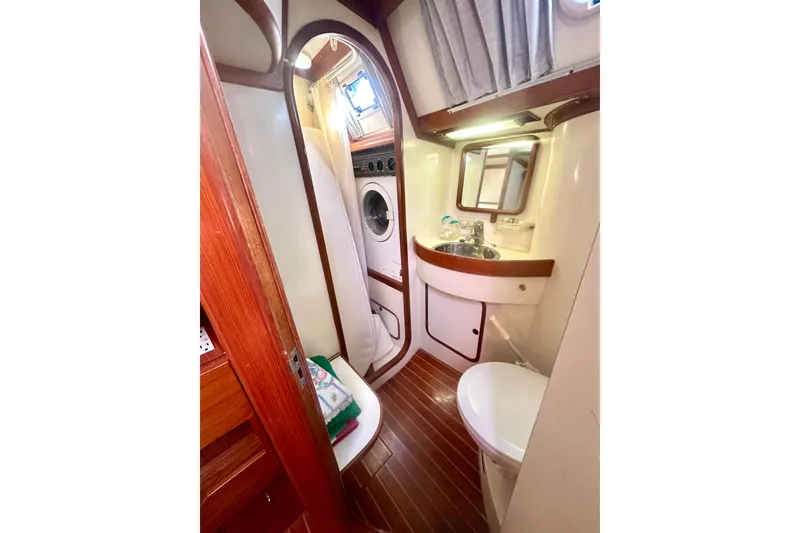 Slide: The Image of 1991 Taswell Sloop bathroom with sink, toilet, and washing machine. - 18