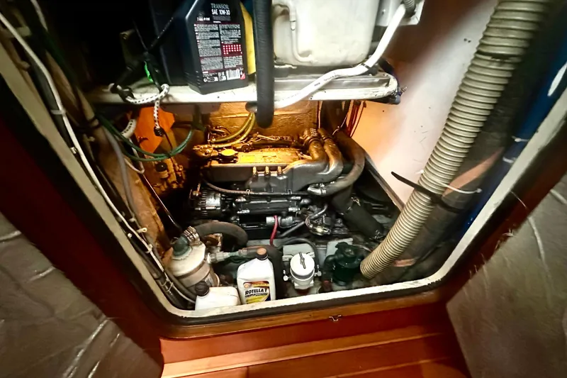 Slide: The Image of Engine compartment of a 1991 Taswell Sloop, featuring mechanical components and oil container. - 19