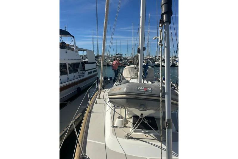 Slide: The Image of 1991 Taswell Sloop docked in a marina, surrounded by other boats. - 25
