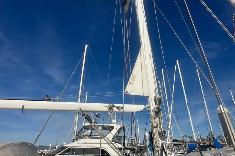 Slide: The Image of 1991 Taswell Sloop sailboat with mast and rigging against a clear blue sky. - 28