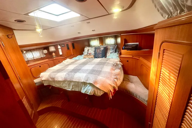 Slide: The Image of Cozy 1991 Taswell Sloop cabin interior with bed, wooden furnishings, and natural light. - 9