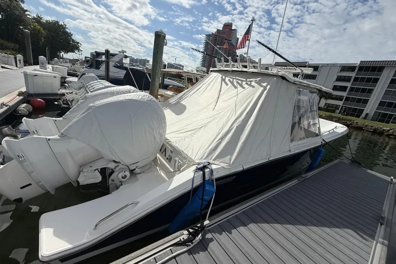 Slide: The Image of 2022 Pursuit S 358 Sport boat docked with covered engines and canopy. - 11