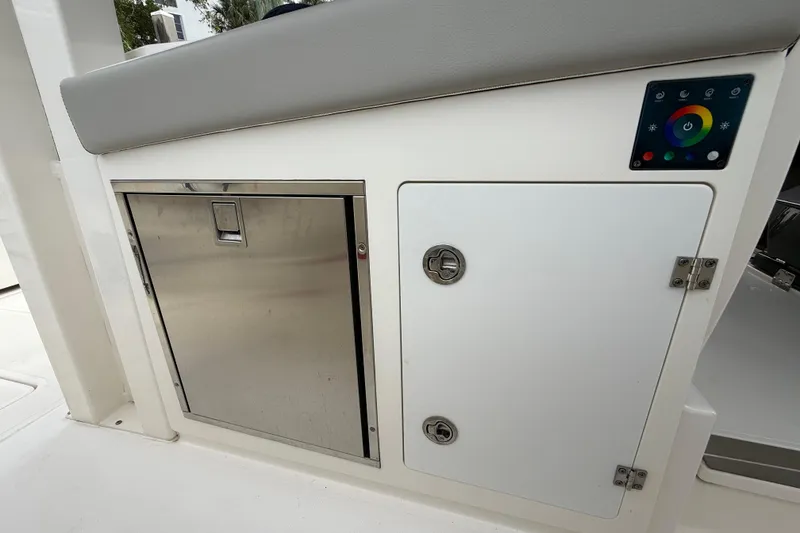 Slide: The Image of 2022 Pursuit S 358 Sport boat interior with storage compartments and control panel. - 116