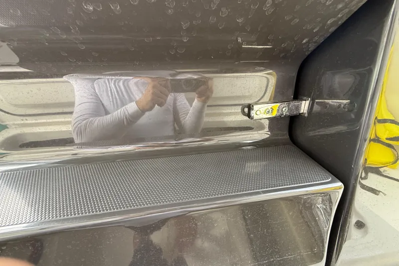 Slide: The Image of 2022 Pursuit S 358 Sport boat interior detail with reflective surface and latch mechanism. - 117