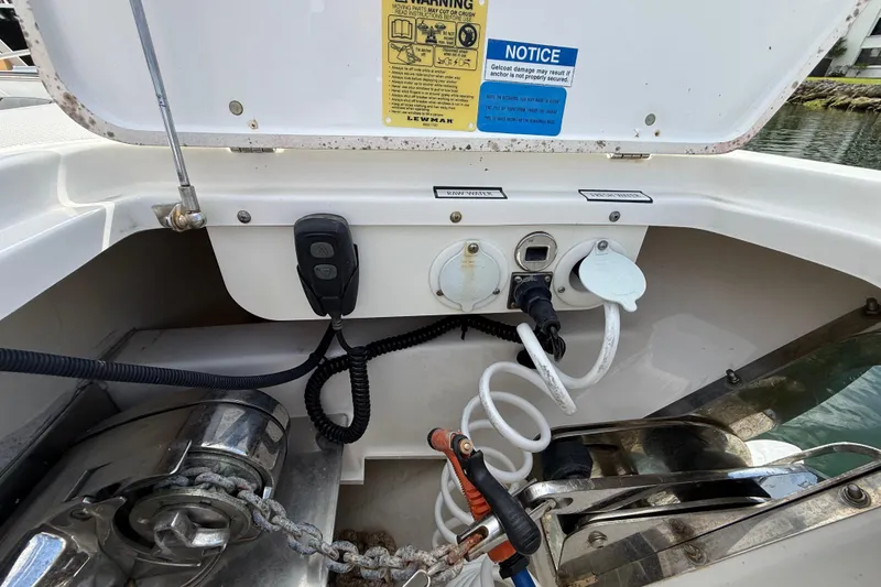 Slide: The Image of 2022 Pursuit S 358 Sport boat anchor compartment with controls and hoses. - 128