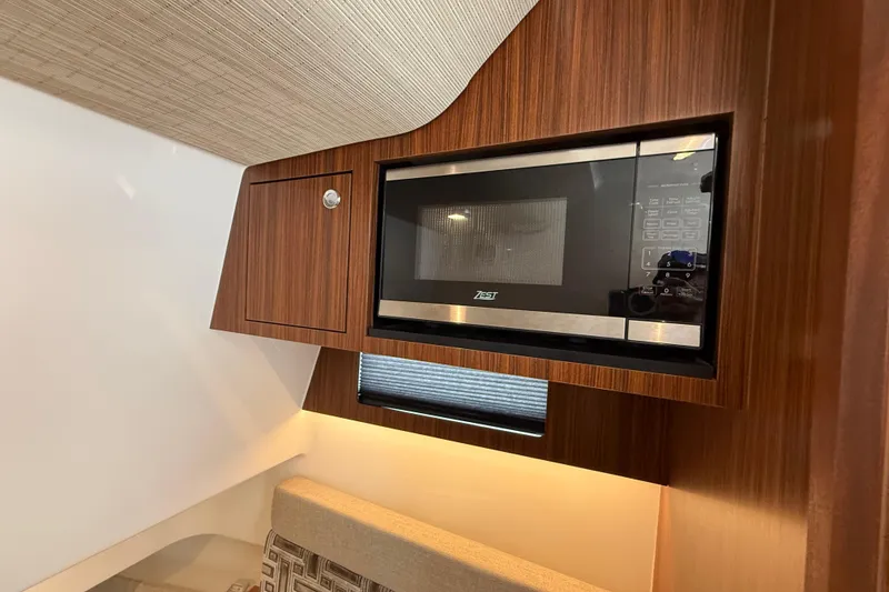 Slide: The Image of Microwave in 2022 Pursuit S 358 Sport boat interior, featuring wood paneling. - 139
