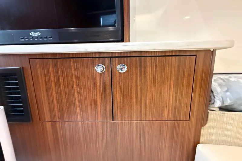 Slide: The Image of Wooden cabinet with chrome handles in 2022 Pursuit S 358 Sport boat interior. - 141
