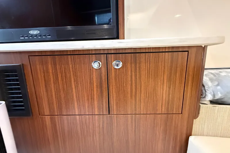 Slide: The Image of Wooden cabinet with chrome handles in 2022 Pursuit S 358 Sport boat interior. - 142