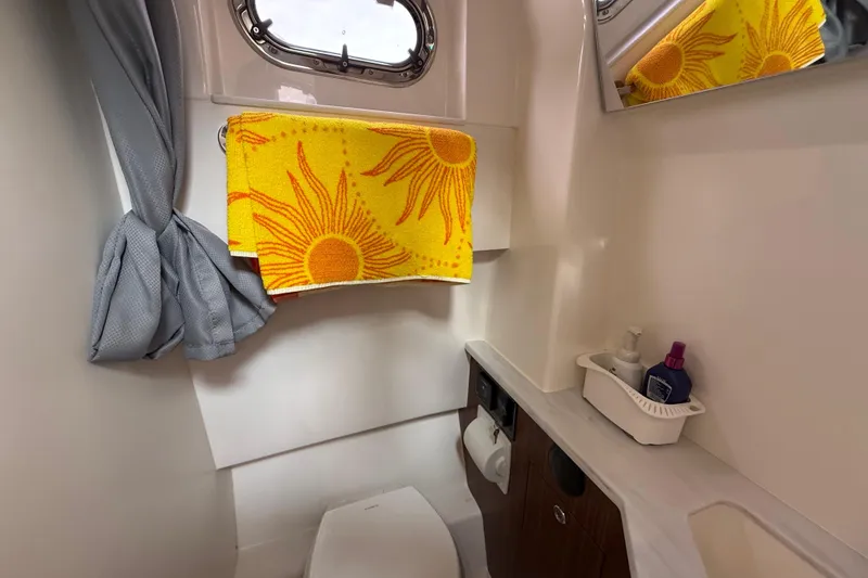 Slide: The Image of 2022 Pursuit S 358 Sport boat bathroom with yellow sunflower towel and toiletries. - 145