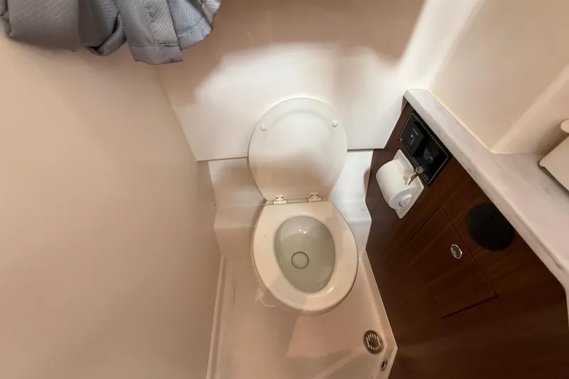 Slide: The Image of 2022 Pursuit S 358 Sport boat bathroom with toilet and wooden cabinetry. - 148