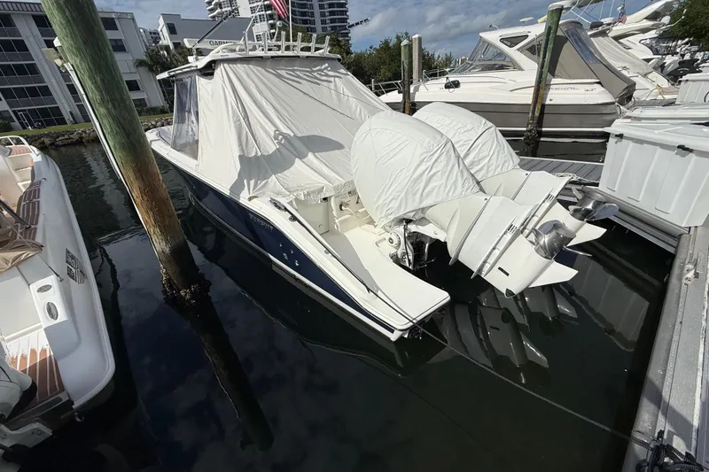 Slide: The Image of 2022 Pursuit S 358 Sport boat docked, covered, with twin outboard engines. - 15