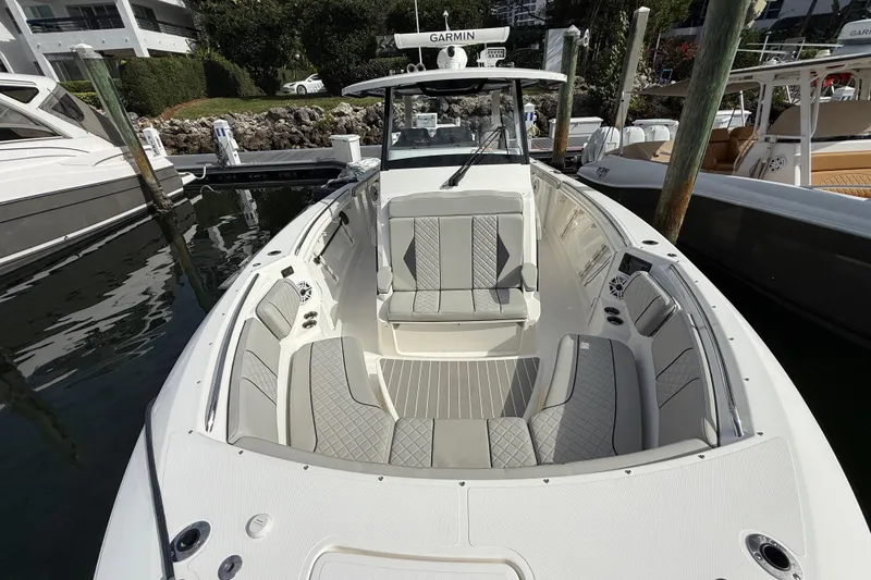 Slide: The Image of 2022 Pursuit S 358 Sport boat with spacious seating and modern design at a marina. - 23
