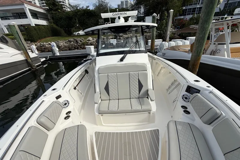 Slide: The Image of 2022 Pursuit S 358 Sport boat with luxurious seating and modern design at a marina. - 26
