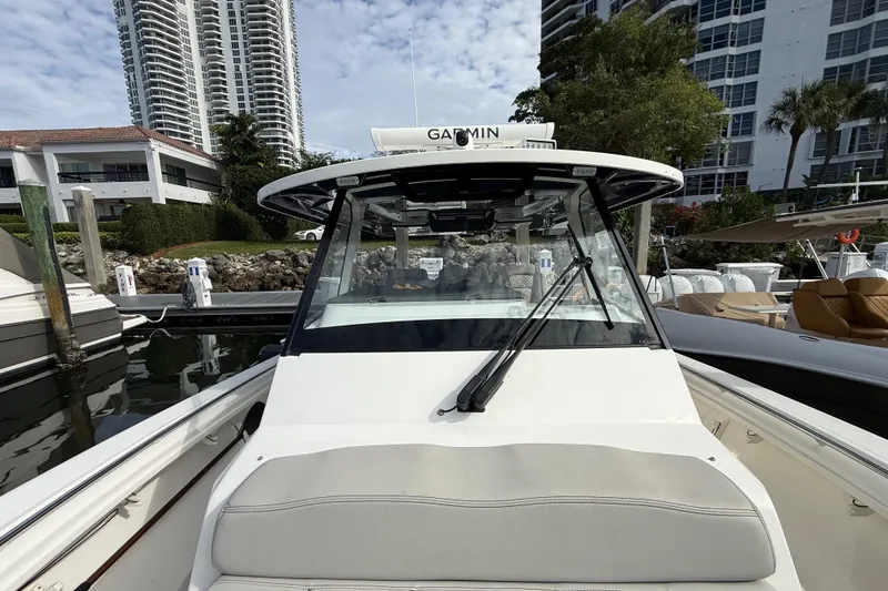 Slide: The Image of 2022 Pursuit S 358 Sport boat docked near luxury buildings. - 29