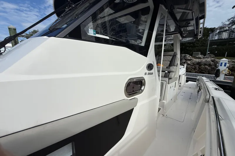 Slide: The Image of 2022 Pursuit S 358 Sport boat, sleek white exterior, docked with modern design features. - 35