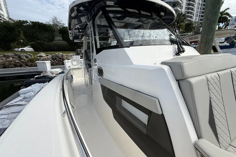 Slide: The Image of 2022 Pursuit S 358 Sport boat docked, showcasing sleek design and luxurious seating. - 37
