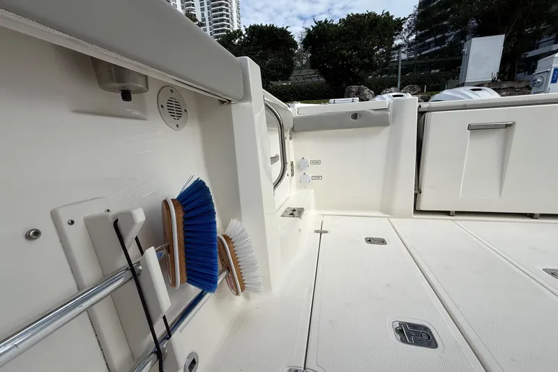 Slide: The Image of 2022 Pursuit S 358 Sport boat deck with cleaning brushes and storage compartments. - 44