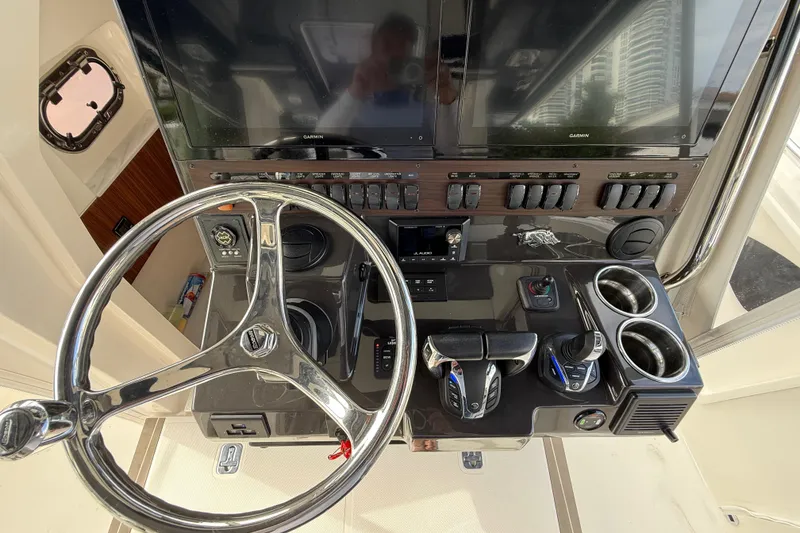 Slide: The Image of 2022 Pursuit S 358 Sport boat helm with steering wheel, controls, and dual Garmin displays. - 45