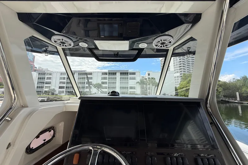 Slide: The Image of Interior view of 2022 Pursuit S 358 Sport boat cockpit with cityscape background. - 47
