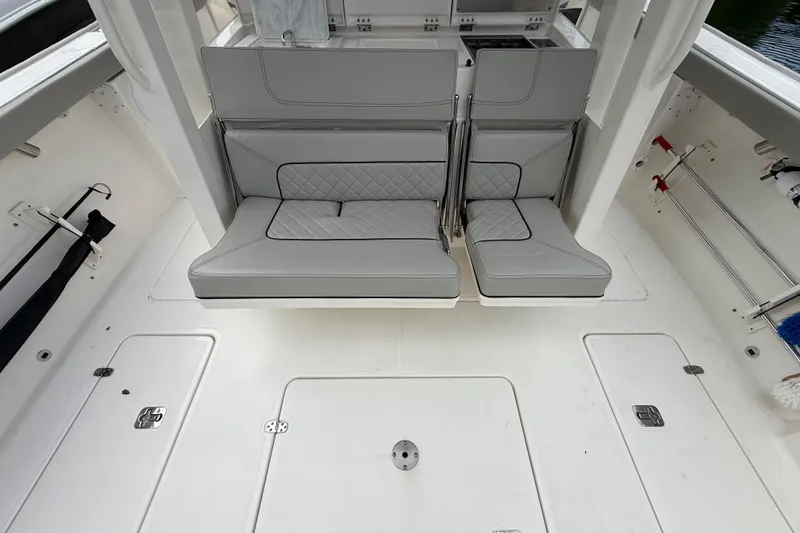 Slide: The Image of 2022 Pursuit S 358 Sport boat interior with gray seating and storage compartments. - 63