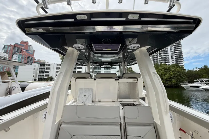 Slide: The Image of 2022 Pursuit S 358 Sport boat interior with modern seating and storage, docked near buildings. - 65