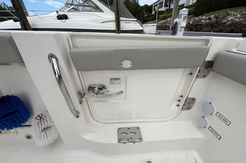 Slide: The Image of 2022 Pursuit S 358 Sport boat interior with door, handle, and water access points. - 77