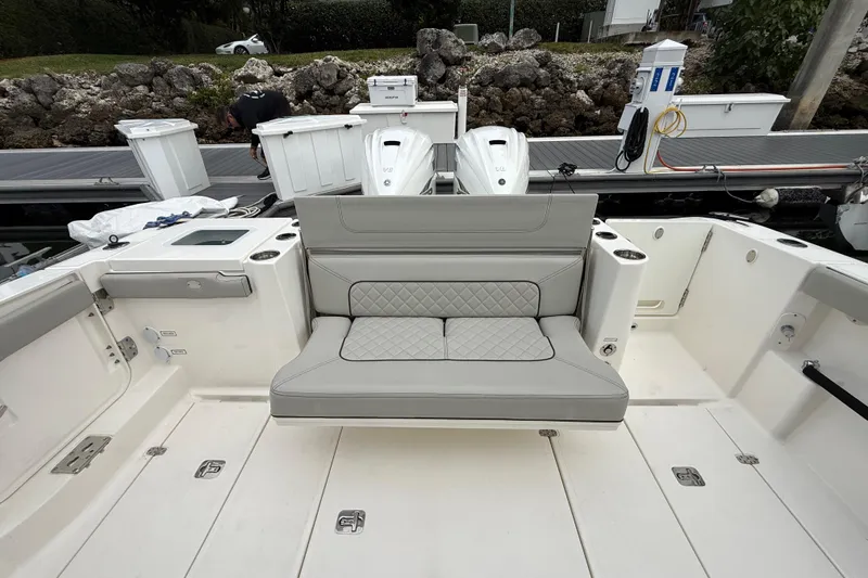 Slide: The Image of 2022 Pursuit S 358 Sport boat interior with cushioned seating and storage compartments. - 78