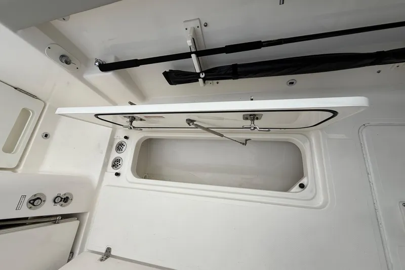 Slide: The Image of 2022 Pursuit S 358 Sport boat storage compartment with open hatch and visible interior. - 80