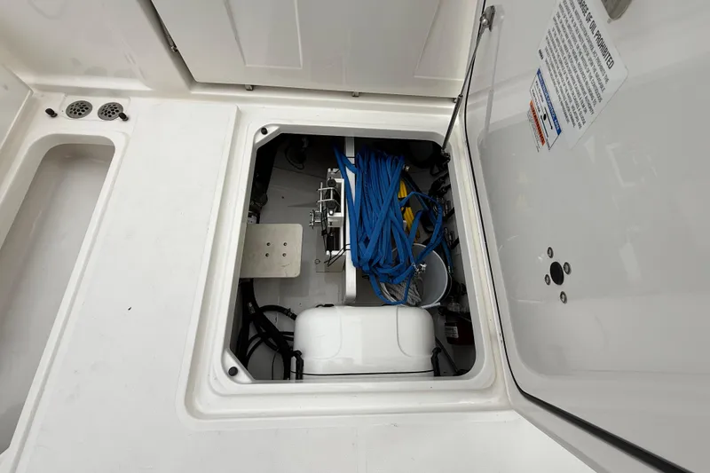 Slide: The Image of 2022 Pursuit S 358 Sport boat storage compartment with blue ropes and equipment. - 81