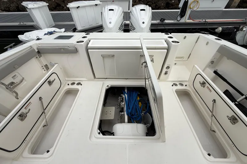 Slide: The Image of 2022 Pursuit S 358 Sport boat deck with storage compartments and engine access. - 82