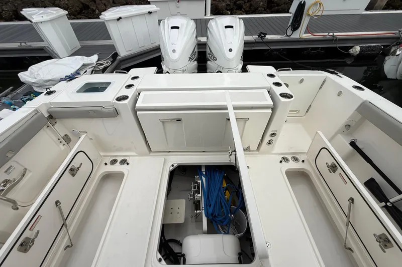 Slide: The Image of 2022 Pursuit S 358 Sport boat interior with storage compartments and twin outboard engines. - 83