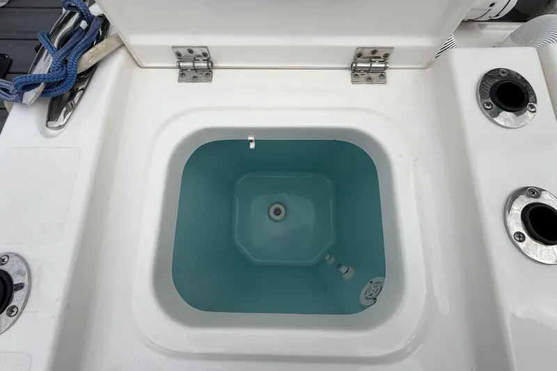 Slide: The Image of Livewell compartment on a 2022 Pursuit S 358 Sport boat, featuring rod holders. - 97